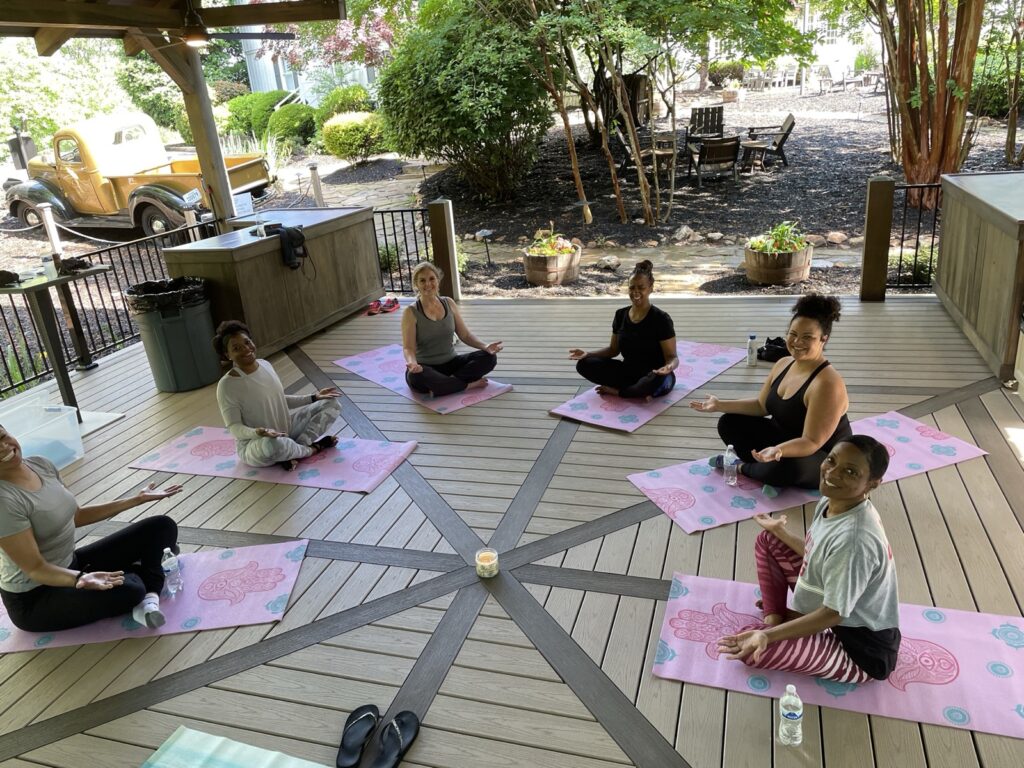 Women seated in a meditation circle on an outdoor deck
