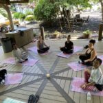 Women seated in a meditation circle on an outdoor deck