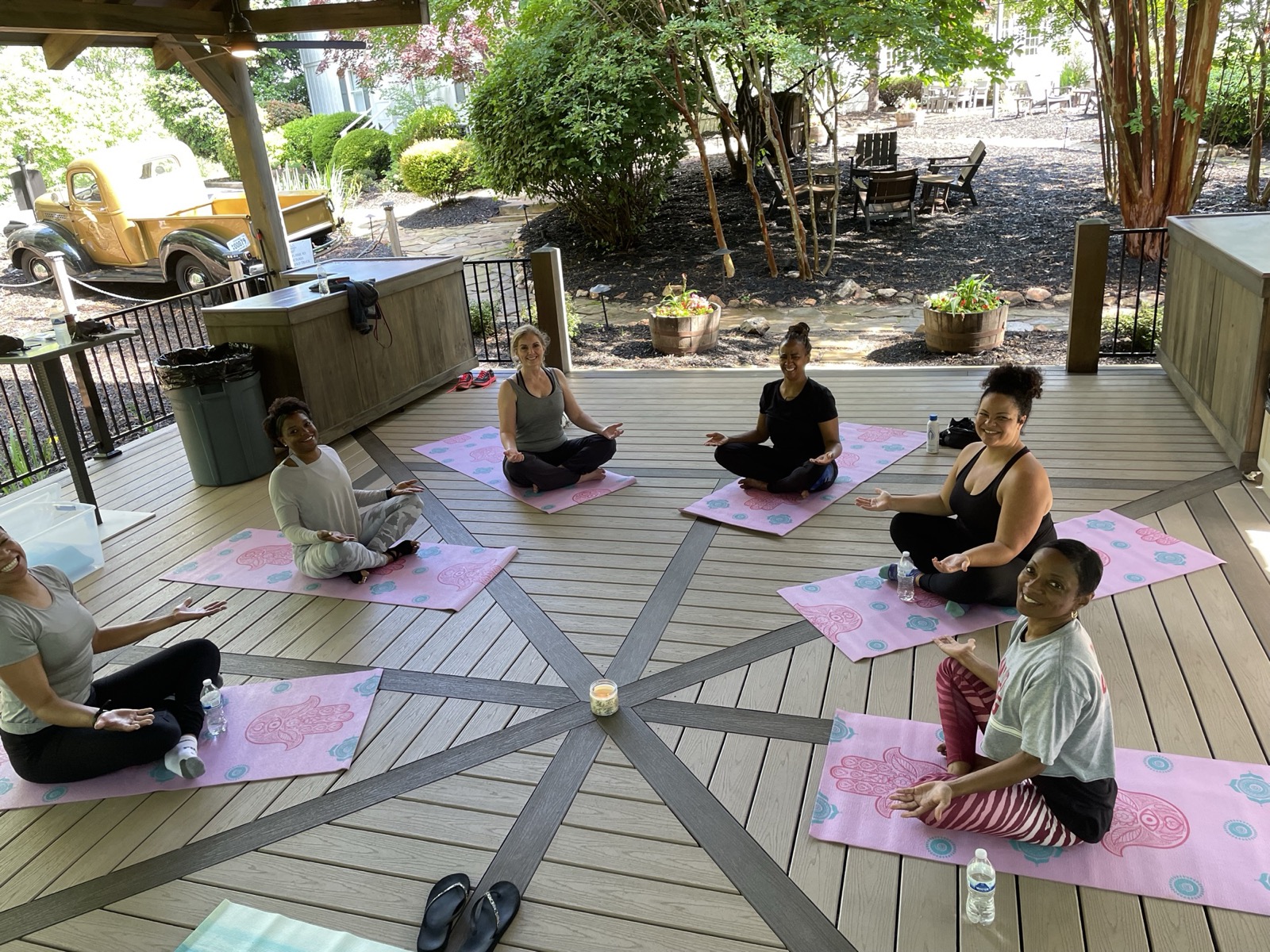 Women seated in a meditation circle on an outdoor deck
